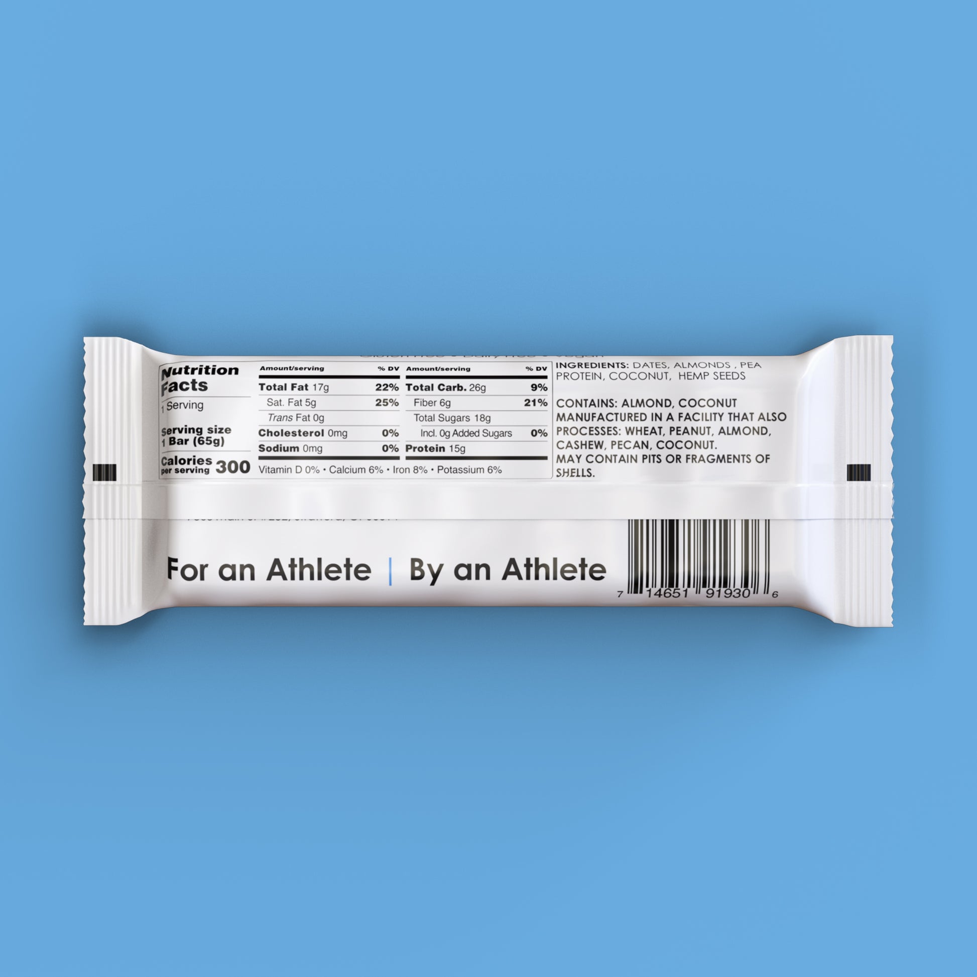 An almond coconut TIROBAR, a vegan and all natural protein bar, sits in a white wrapper against a blue background. The bar is visible from the top with a clear view of the nutrition facts. For an Athlete | By an Athlete