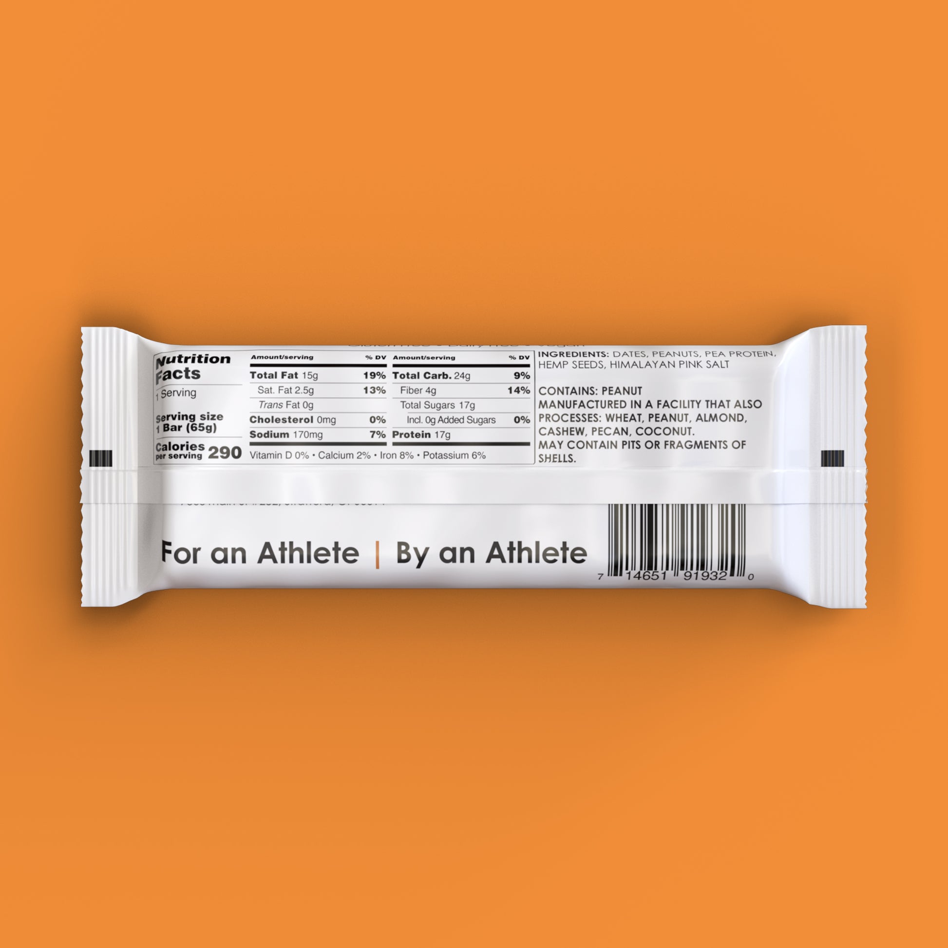 A salted peanut TIROBAR, a vegan and all natural protein bar, sits in a white wrapper against an orange background. The bar is visible from the top with a clear view of the nutrition facts. For an Athlete | By an Athlete.